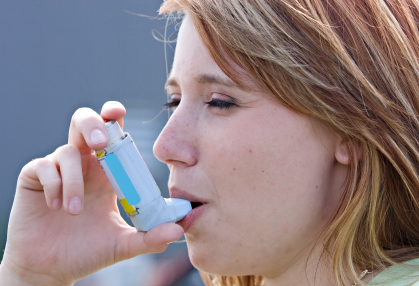 Lady with respiratory problem using an Asthma Inhaler