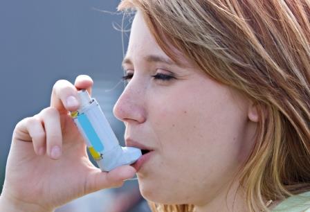 Person using asthma inhaler